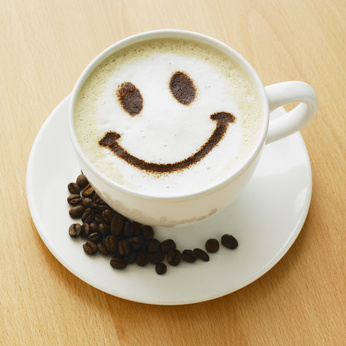 Cappuccino with smiley face and coffee beans.